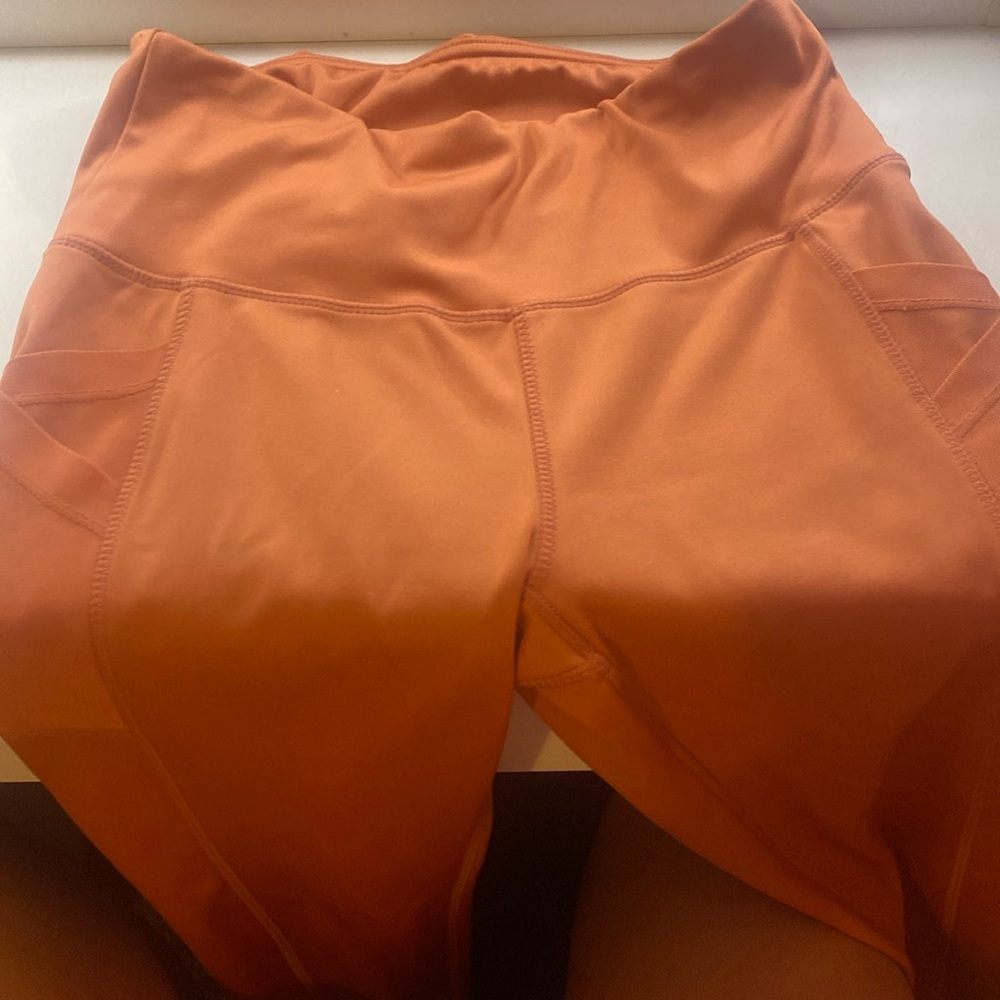 Pink/orange leggings/pants crisscross motion by the pockets